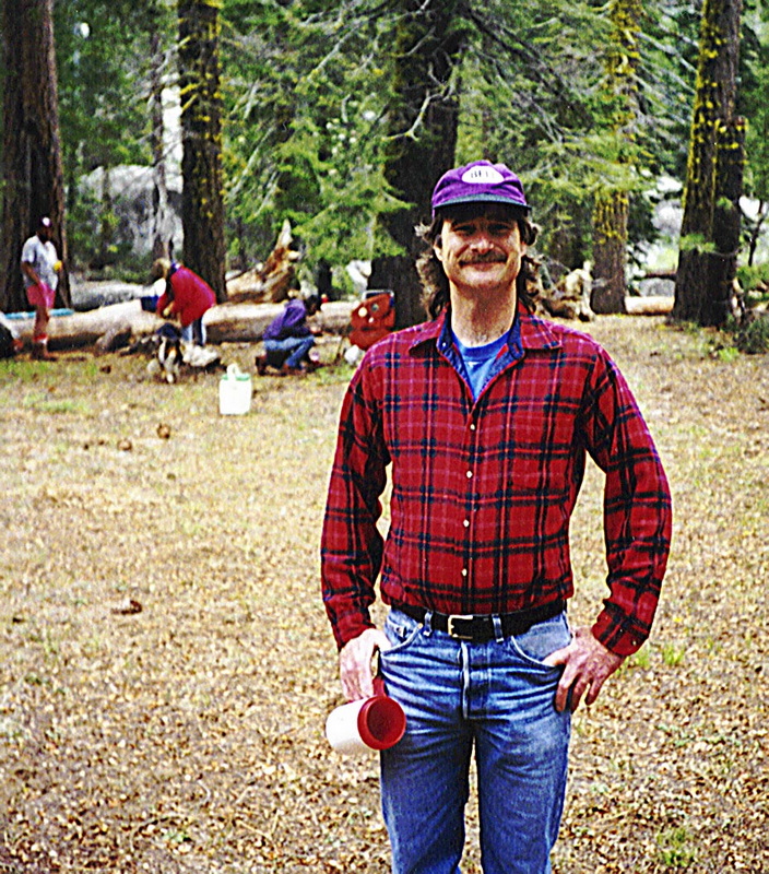 Man in red flannel at camp with Kegger mug