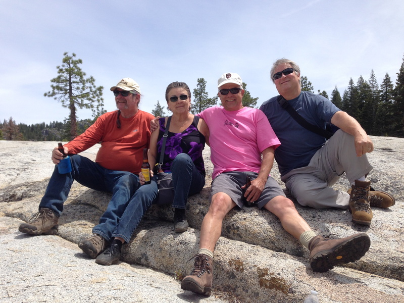Four friends sitting on the granite rock at the Kegger campsite during Tom Caton's memorial, 2014