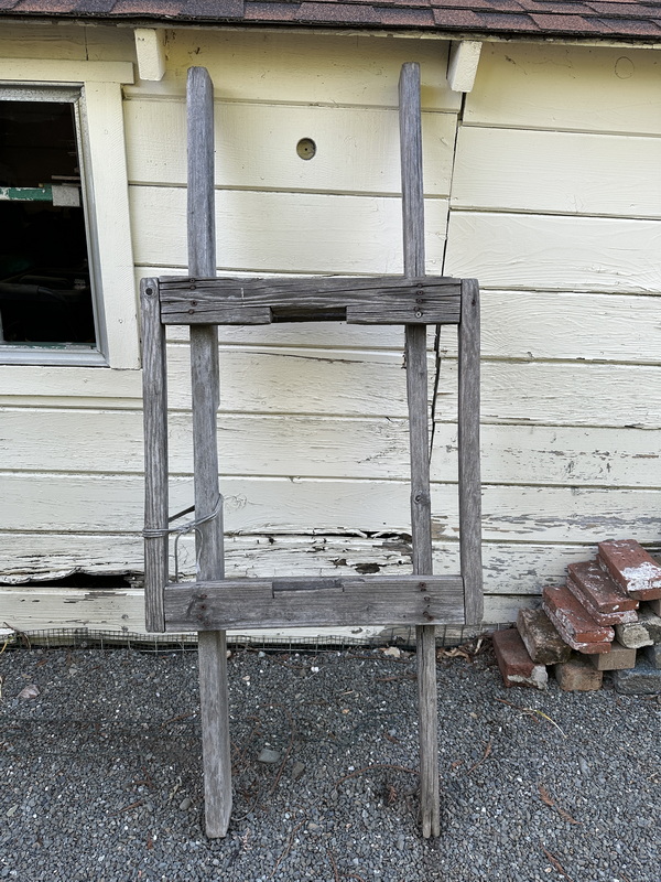 The original wooden keg stretcher — weathered 2x4 lumber leaning against a house, 50 years old