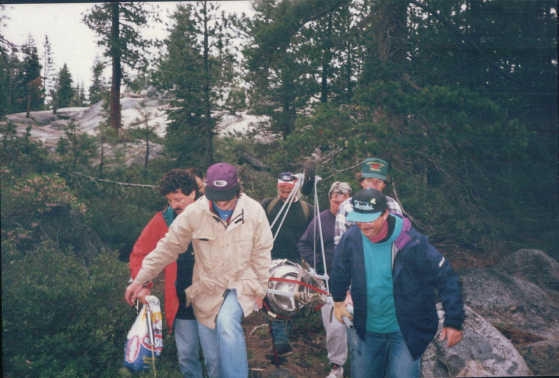 The Wheely stretcher being carried in on the trail — team of six navigating granite and forest with keg
